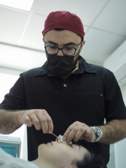 Пластический хирург Паруйр Минасян снимает гипс пациентке после ринопластики